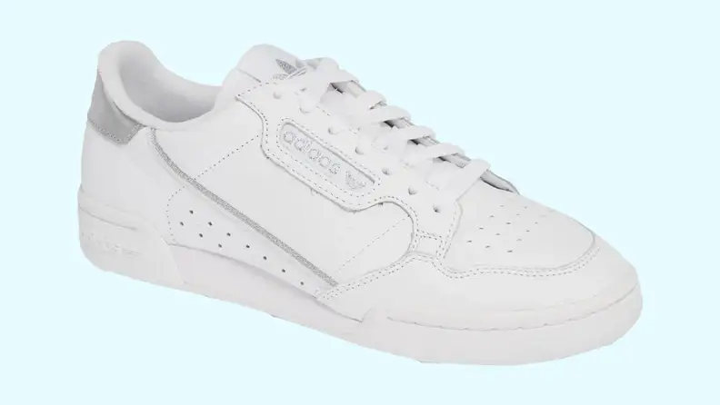 A white adidas Continental sneaker, on a light blue background.