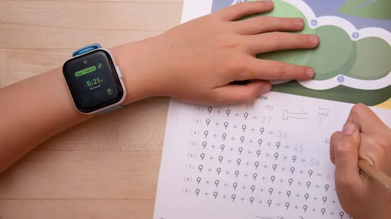 A child's wrist wearing a smartwatch.