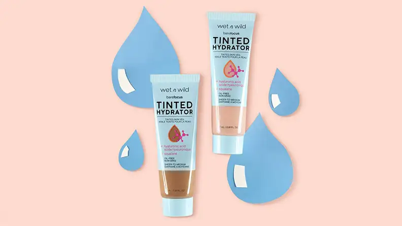 Two Wet n Wild Bare Focus Tinted Hydrators in light and dark skin tones sitting on top of a light pink background with animated water droplets in back of them.