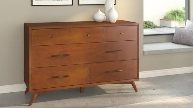 Wooden dresser with seven drawers indoors.