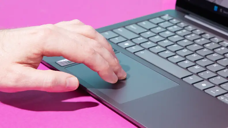 Person resting their fingers on the trackpad of the Lenovo Slim 7 laptop.
