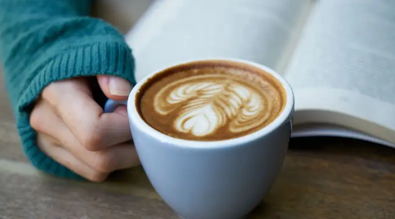 Person drinking coffee and reading