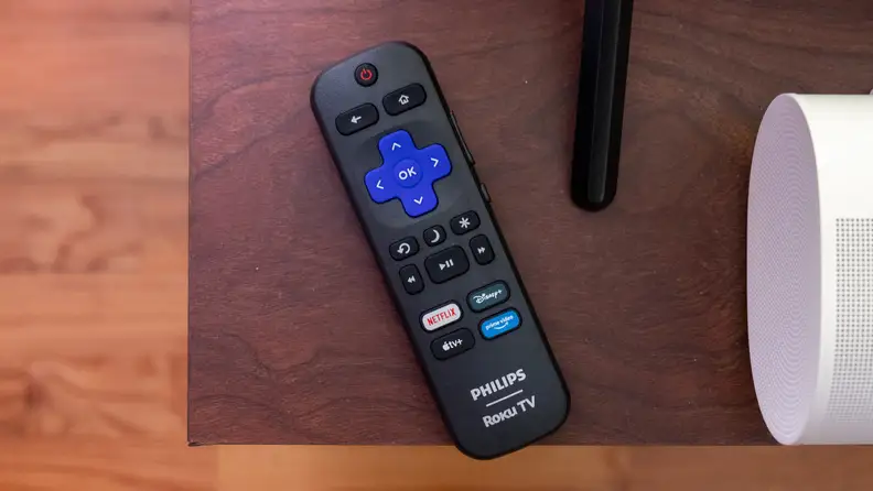 Roku remote on a wooden surface for the Philips Ambilight 7985 TV.