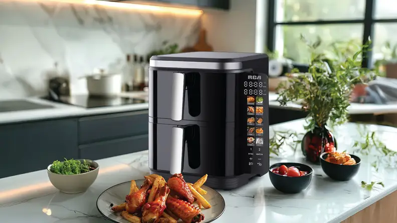 RCA black air fryer on counter with cooked food.