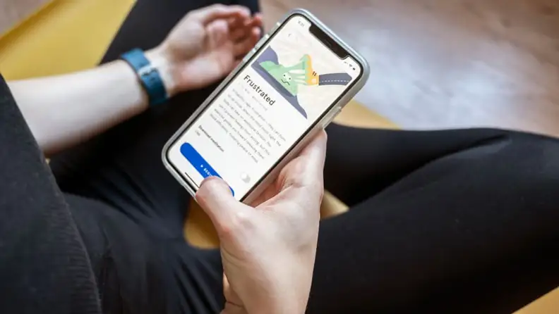 a person holds their phone with the headspace app open