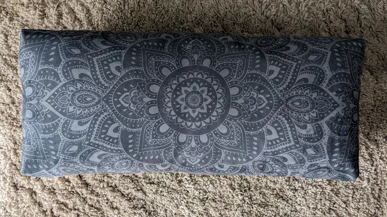 Yoga Design Lab Bolster resting on a carpeted floor