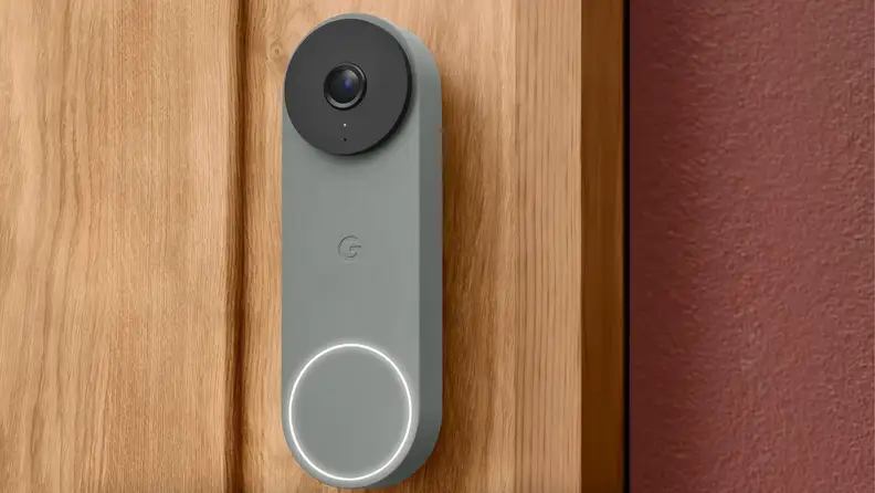 A gray doorbell is on a brown wood wall