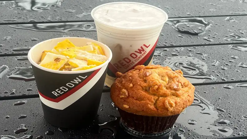 Red Owl cups with egg bites and a walnut muffin on a wet table