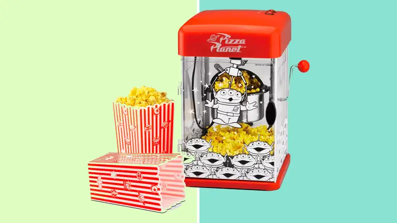 A red popcorn maker on a green background