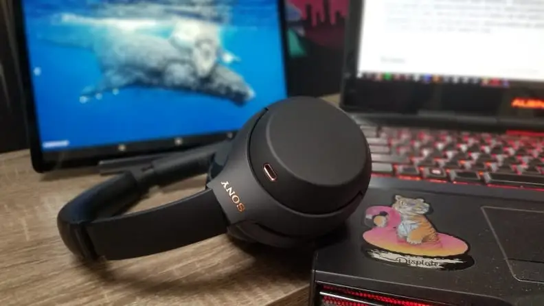 Headphones rest on a computer desk.