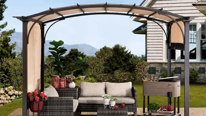 Pergola above cream patio furniture outdoors.