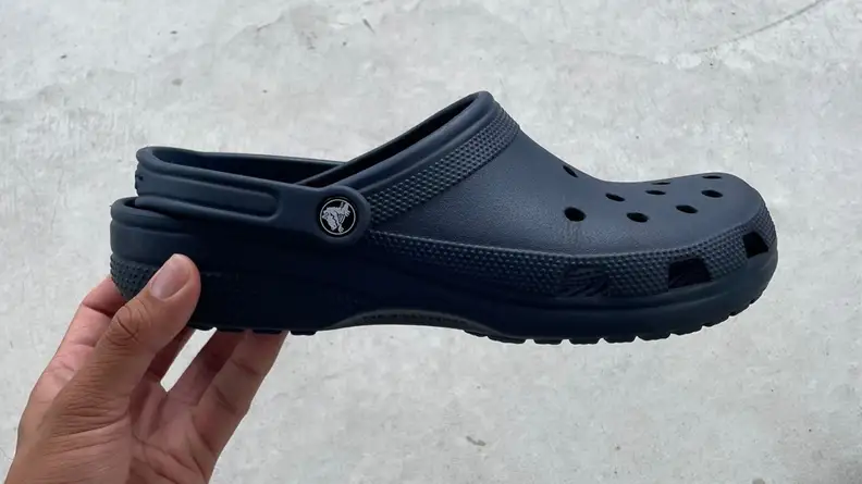 hand holding navy Crocs
