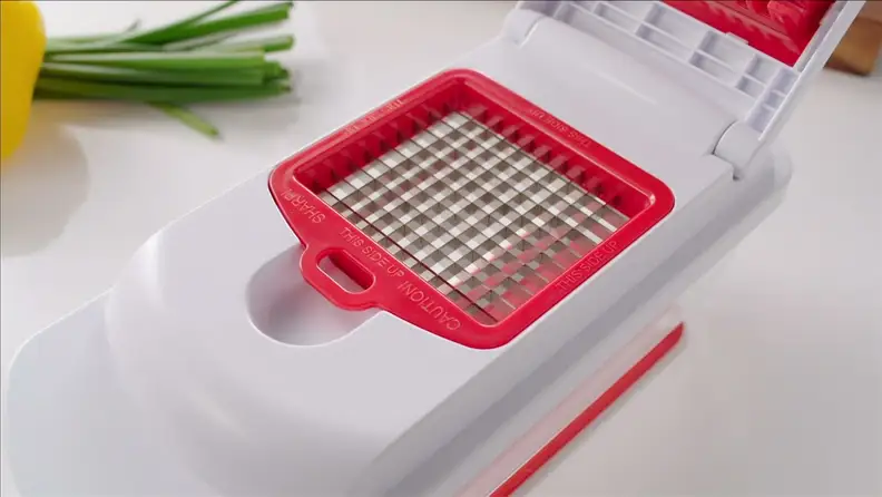 Red veggie chopper on cutting board