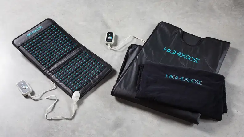 The Higher Dose Infrared Sauna Blanket and the Infrared PEMF Go Mat side-by-side on a floor.