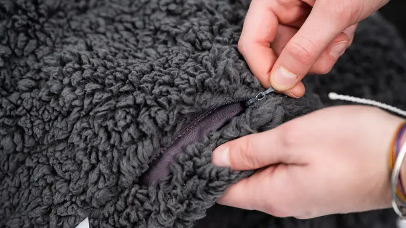 a persons hands pull at the zipper on the yaasa blanket