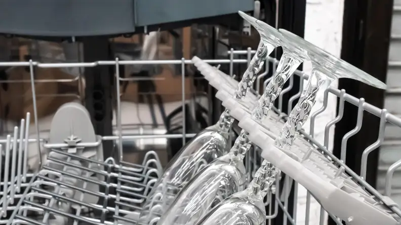 A row of stemware sits in the Bosch 500 Series SHPM65Z55N dishwasher's middle rack, their stems cradled by the plastic latticework of the stemware holsters.