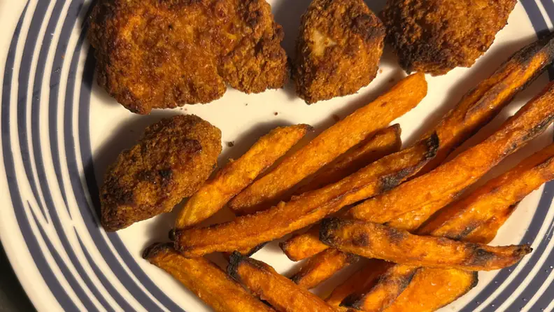 Chicken nuggets and french fries shown cooked by the Our Place Wonder Oven Pro on a plate.