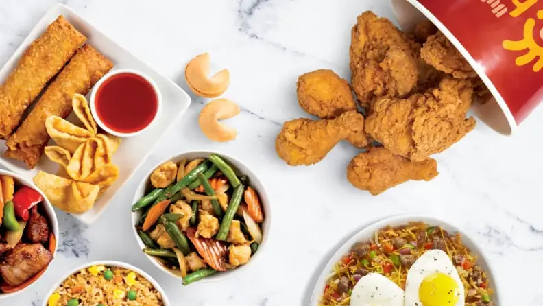 Spread of fried chicken, egg rolls, stir-fry, fried rice, and fortune cookies