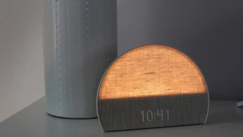 The Hatch Restore 2 lit up in yellow on a nightstand
