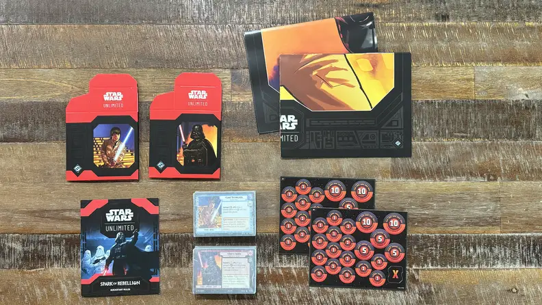 The contents of the Star Wars: Unlimited two-player starter kit on a wooden coffee table.