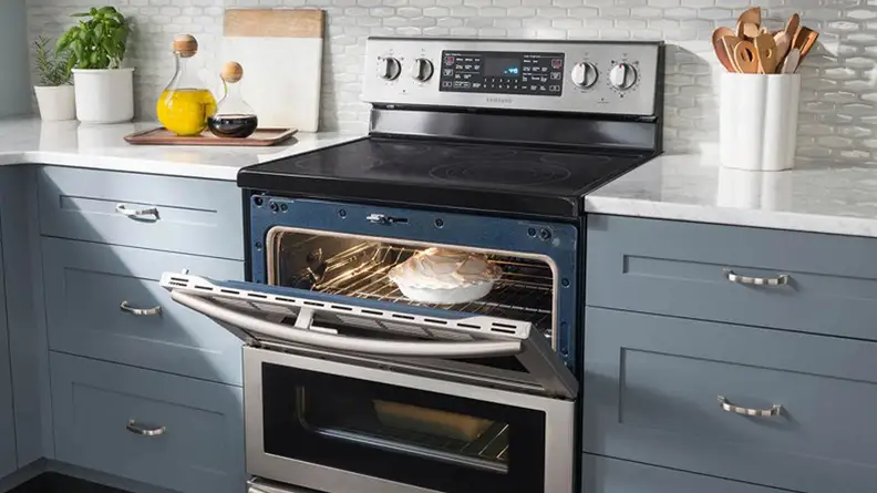 The  Samsung NE59J7850WS electric range shown with it's top oven door open. There is a lemon meringue pie in the oven.