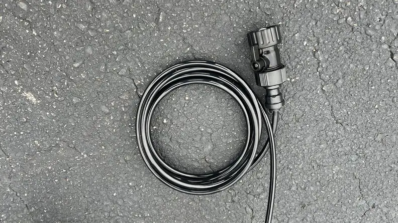 Black coiled-up hose with attached faucet hook-up and shut-off valve.