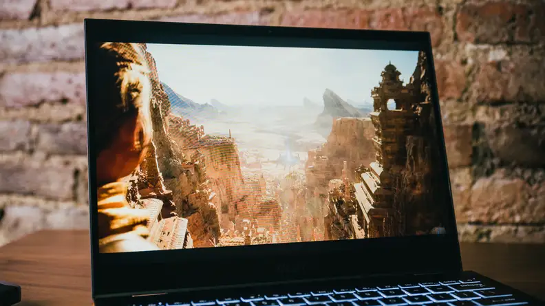 The laptop sits on a table, open and on.