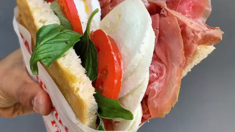 A hand holding a sandwich