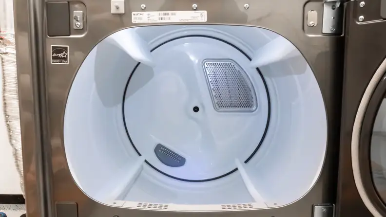A close-up of the Maytag MED8230HC dryer's drum, lit by an internal LED