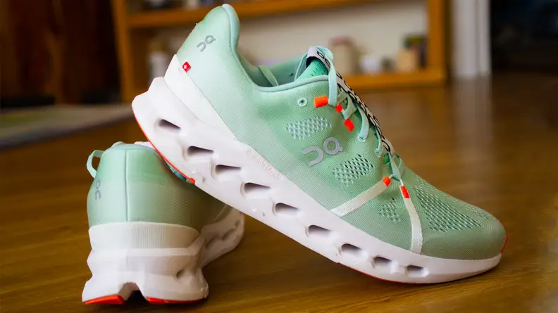 The On Cloudsurfer sneakers are positioned leaning against each other.