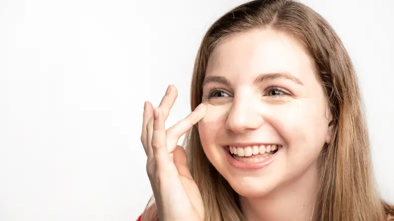 The author blending out the Tarte Shape Tape Concealer on her face.
