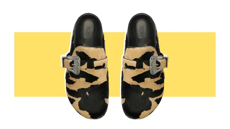 A pair of calf hair clogs that have a leopard print.