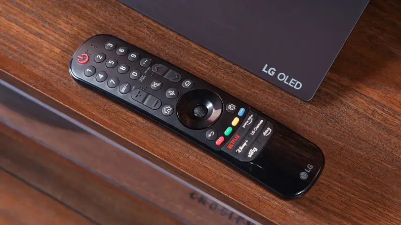 The remote of the LG C3 OLED TV on a TV stand.