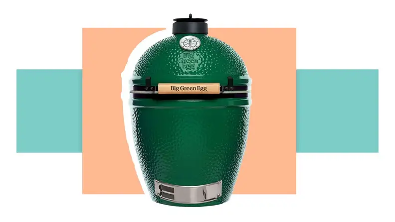 The Green Egg charcoal grill in front of a background.