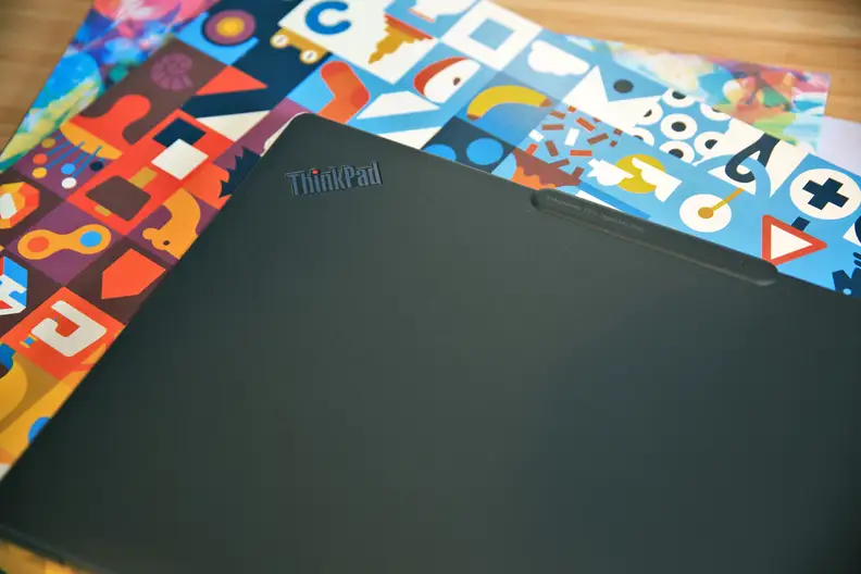 The top of a black laptop against a colorful backdrop