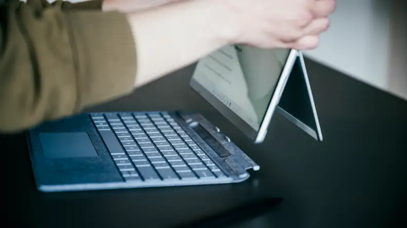 A side view of the Pro 8, propped up by the kickstand, with the Type Cover attached.
