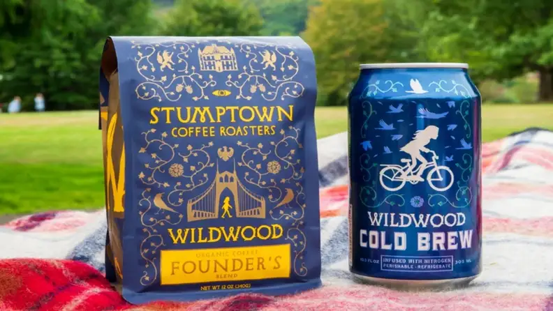 Coffee bag and cold brew can resting on a picnic blanket