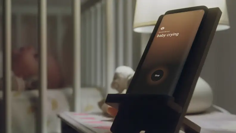A Samsung Galaxy smartphone is proped up beside a baby crib to demonstrate a baby-monitor software upgrade.