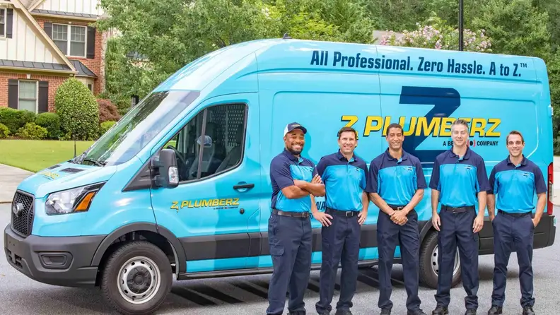Five technicians standing in front of a branded service van