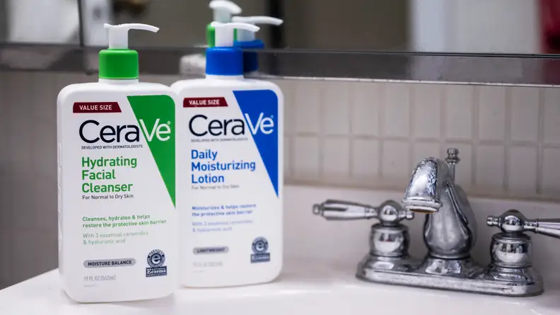 Two pump bottles of cleanser and moisturizer sit on the bathroom sink.
