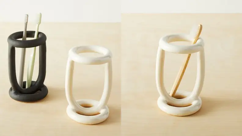 A black and two white toothbrush holders.