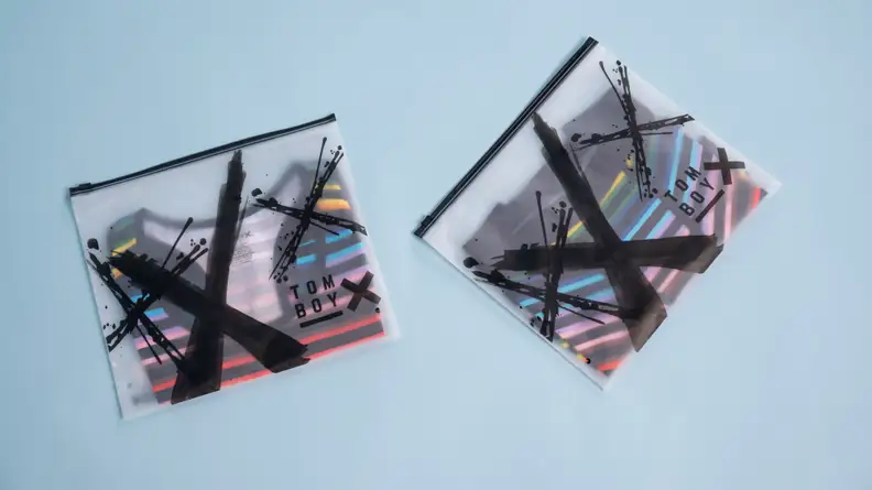 TomboyX products in bags against blue background.