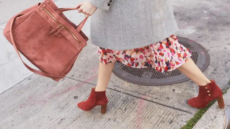 A woman in red boots crossing the street.