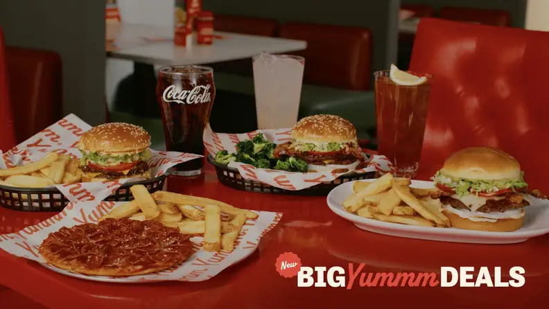 A spread of Red Robin burgers, pizza, fries, and drinks with a "Big Yummm Deals" banner