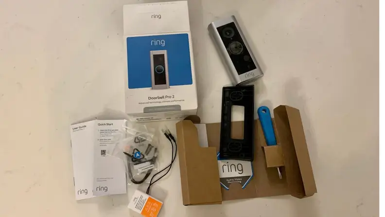 Everything inside of the Ring Video Doorbell Pro 2 laid out on a white quartz countertop.