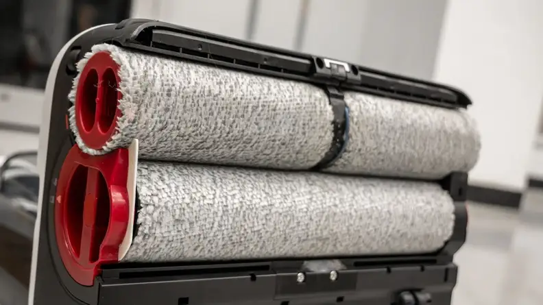 Three white rollers at the bottom of a vacuum cleaner