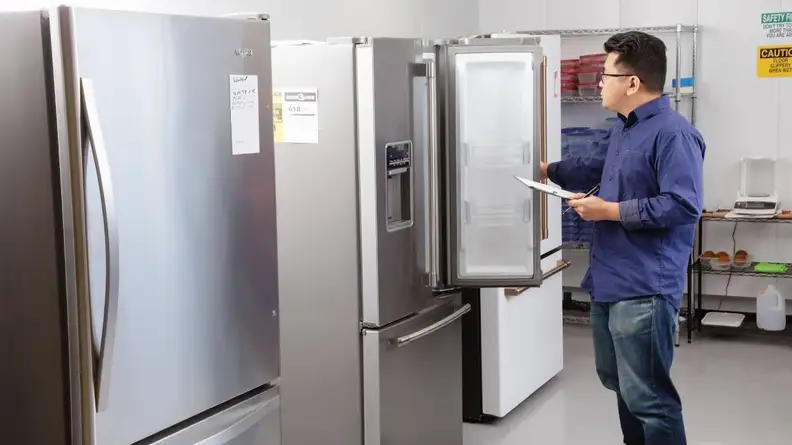 Our lab operations manager, Jonathan Chan, stands before a line-up of fridges in our testing lab.