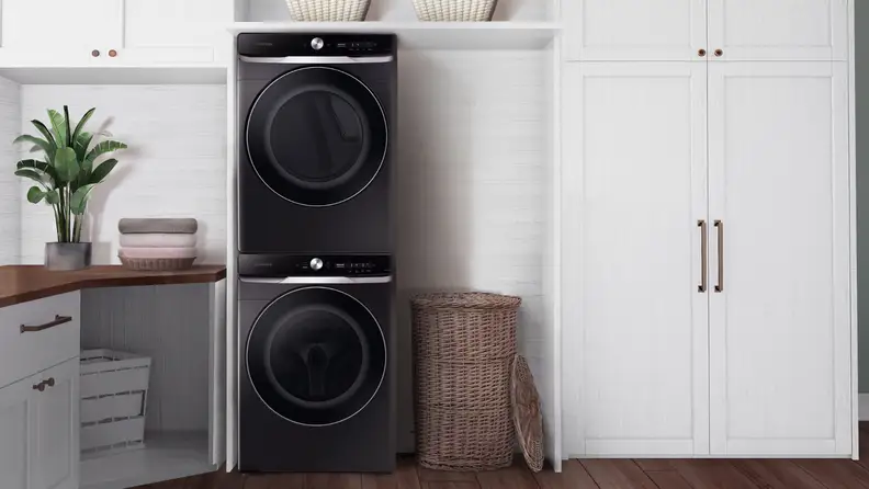 A laundry room with a stacked washer dryer in matte black.