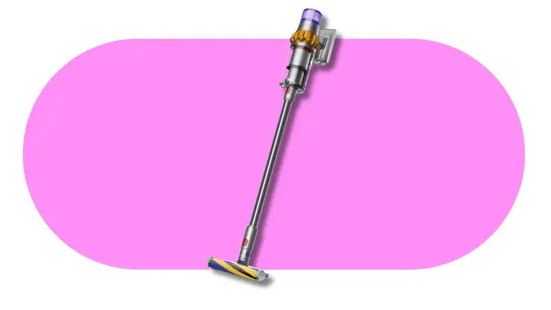 Cordless stick vacuum cleaner standing against a pink background.