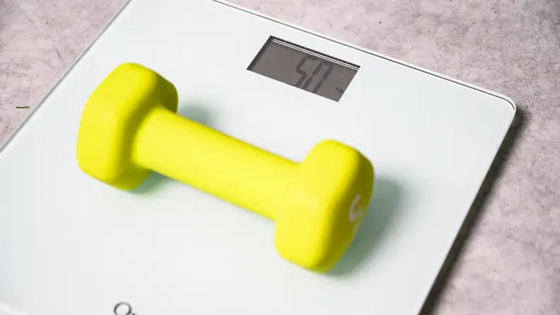 A hand weight placed on a bathroom scale